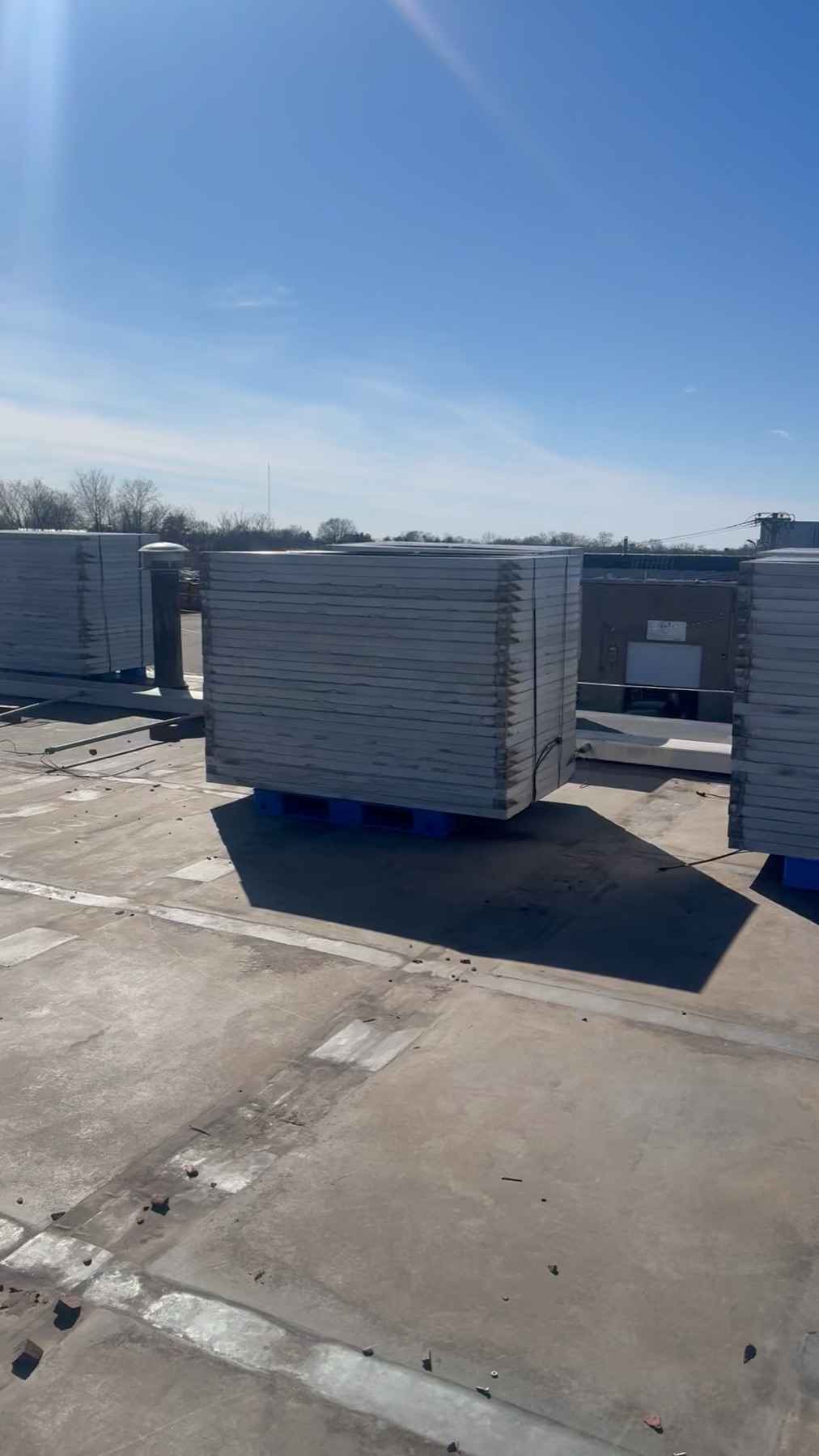 Commercial flat roof prepped with HVAC and pallets for solar install