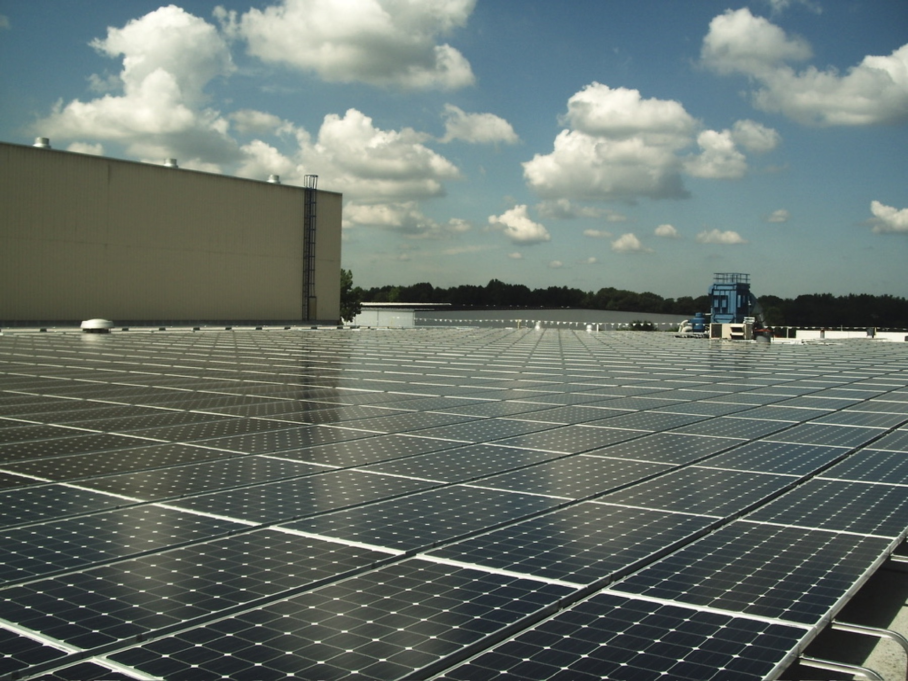 Wide drone shot of a large commercial solar array installed by Reliant Solar