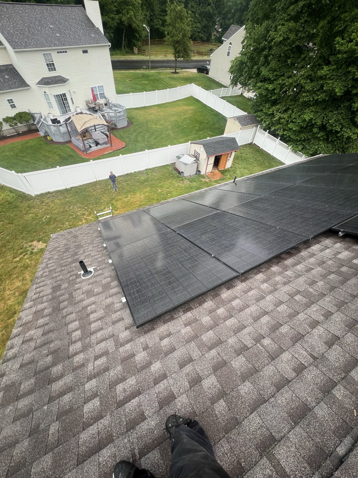 On-roof view of a residential solar array overlooking the backyard